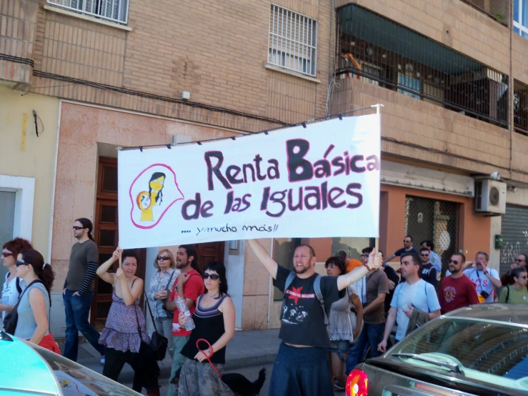 a group of people stand together holding up a banner