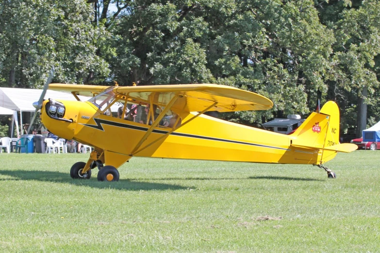 an airplane on wheels sits in the grass