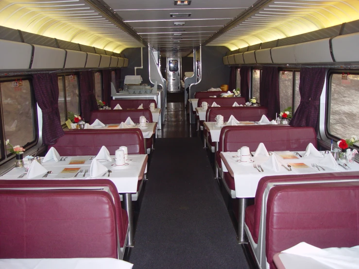 two rows of tables and four benches on the side of a train