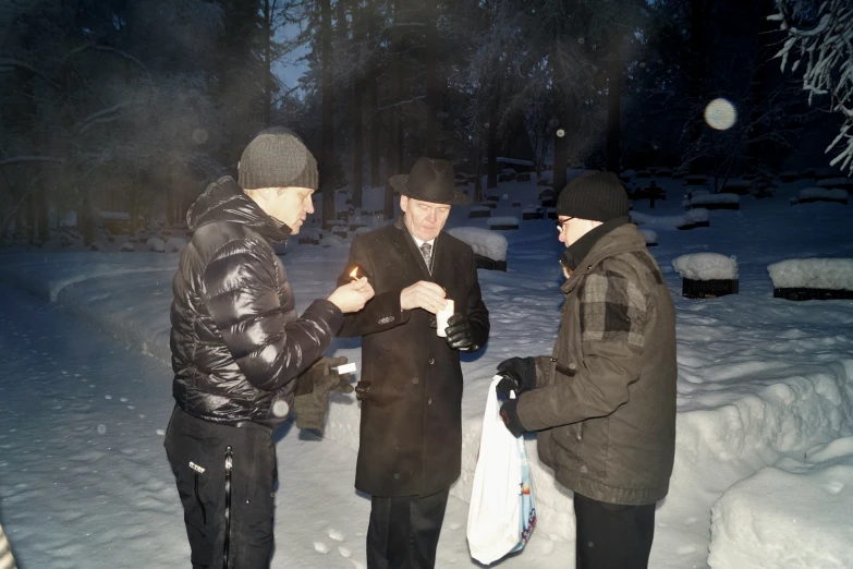 three people standing in the snow talking to each other