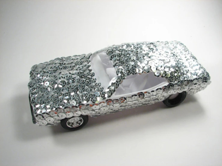 a toy car is covered in silver glitter