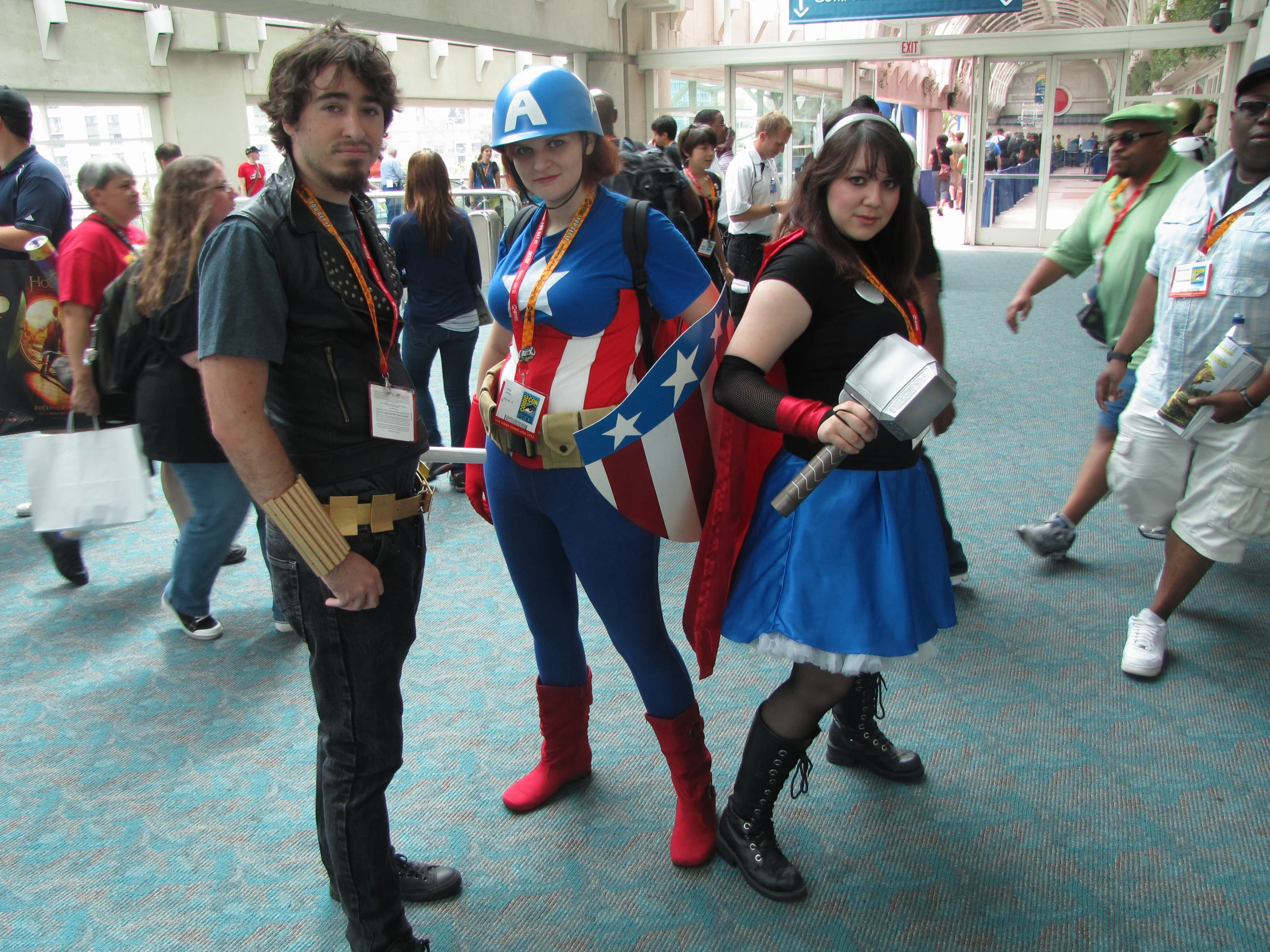 three people in costume pose on a sidewalk