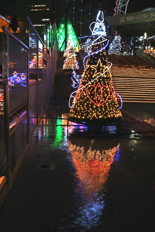 there is a christmas tree lit up on the sidewalk