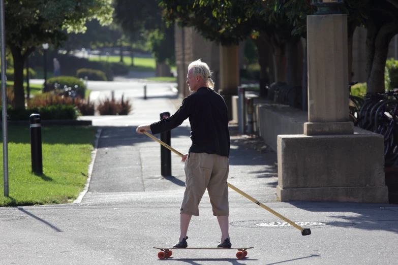 an elderly man skateboarding down the street with two wheels