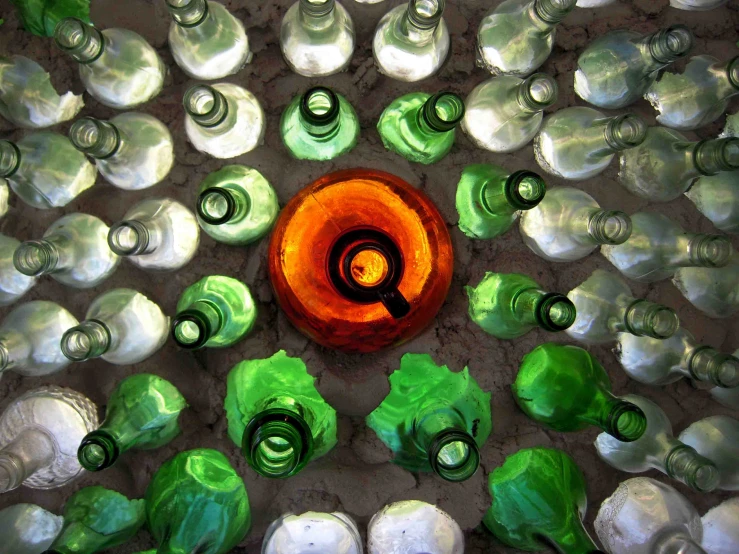 a circle made out of bottles, with an orange and green center