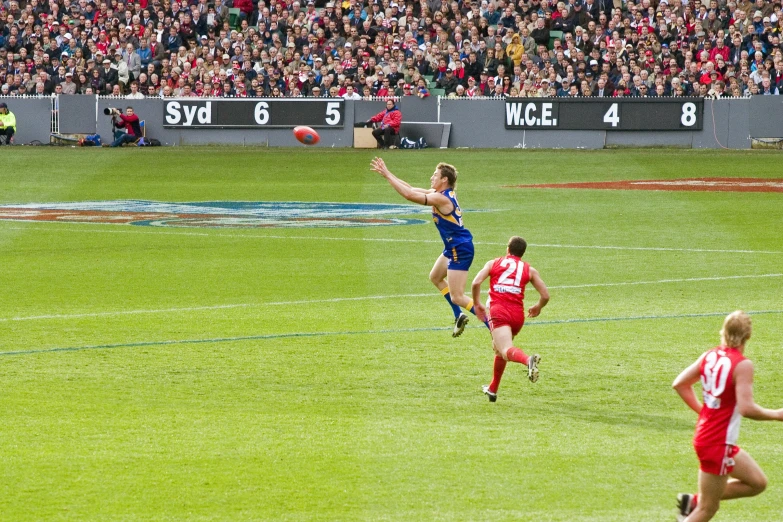 a man leaping up high and catching a football