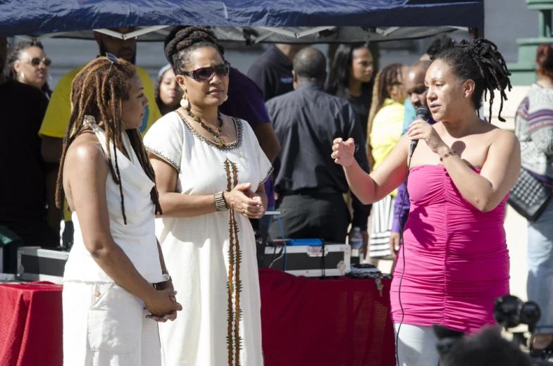 women in white clothing talk about soing on a stage