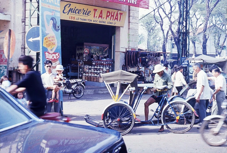 a vintage pograph of people on bikes on a busy city street