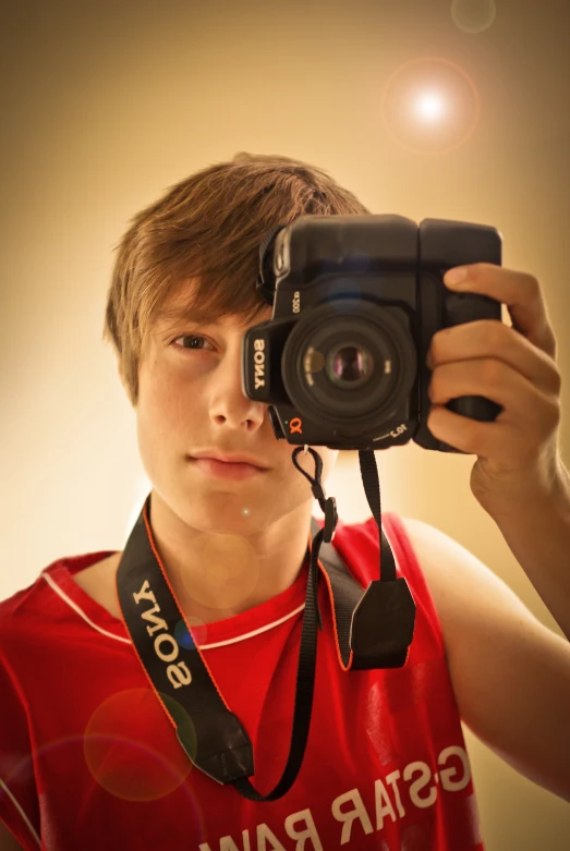 a young man holding up a camera to take a po