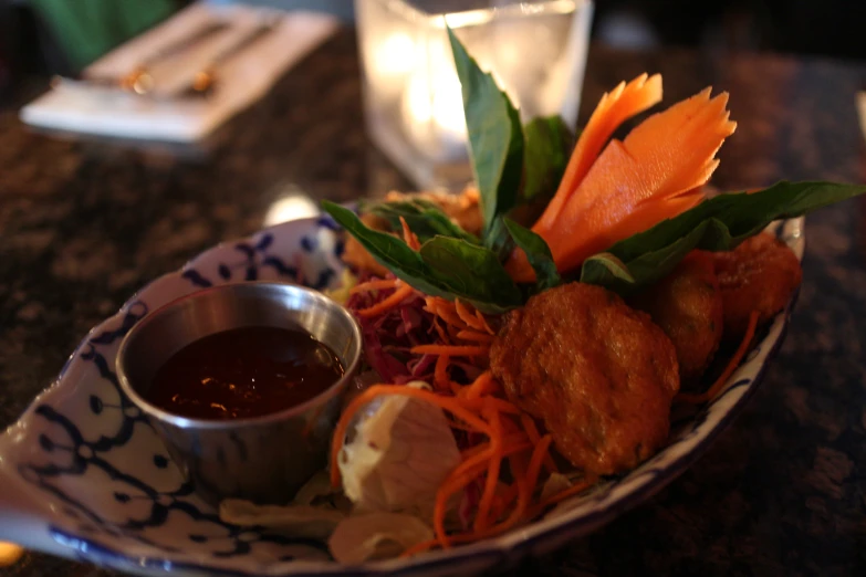 a bowl of food with carrots and sauce in it