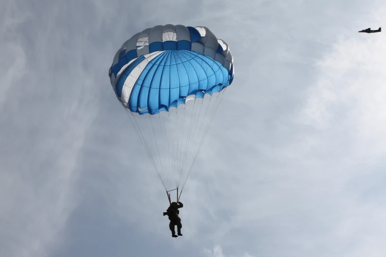 a parasailer in the sky with one hand lifted by two strings