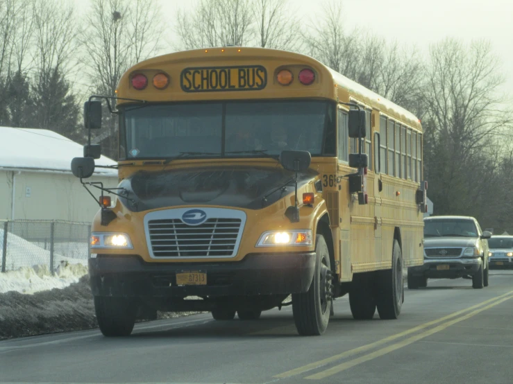 school bus moving on snowy road in rural country setting