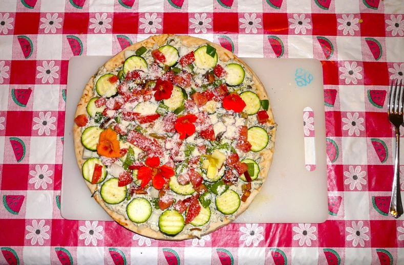 there is an uncooked pizza on a table with vegetables