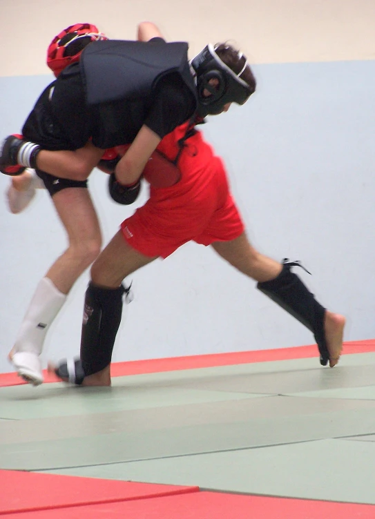 a couple of people are fighting on a mat