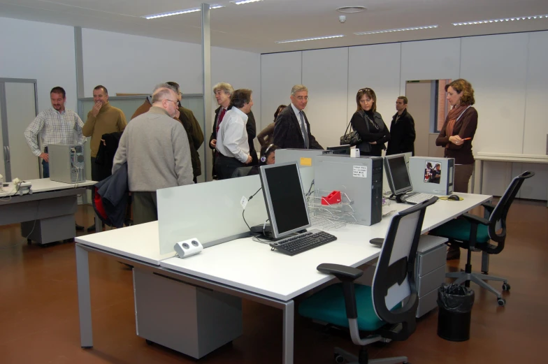 people standing in a room and looking at computers