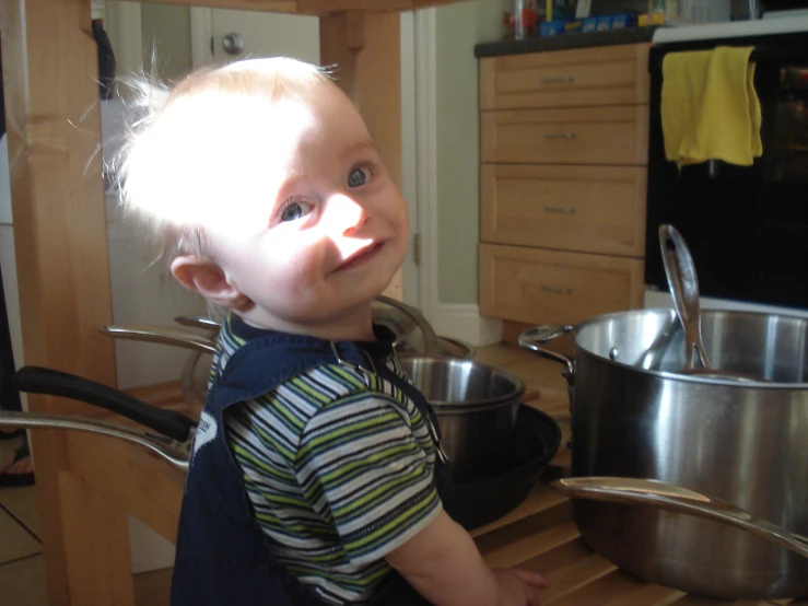 a little  in a kitchen with two pans