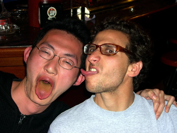 two men taking a po together with their tongues out