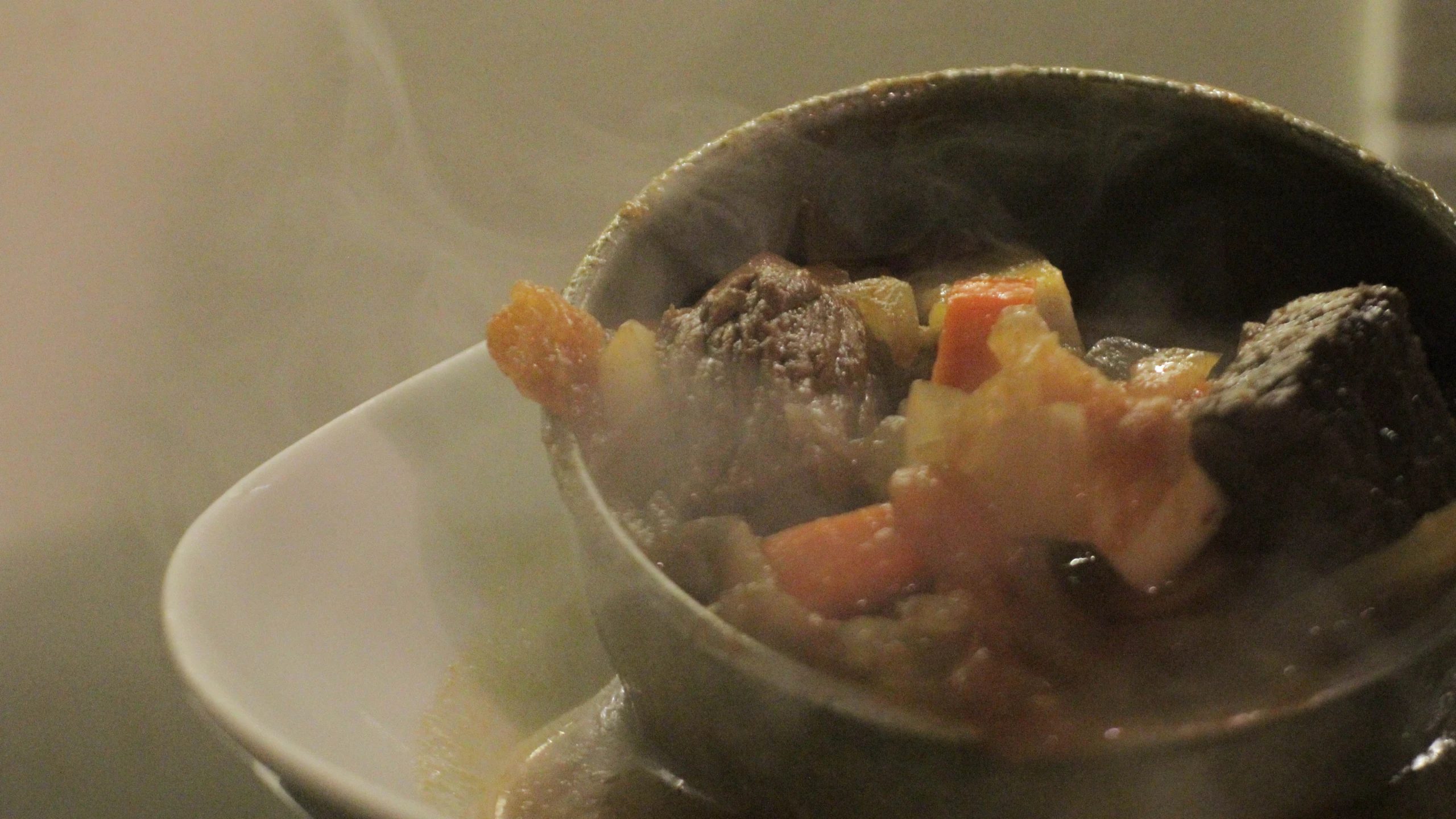 an old fashioned pan holds a food dish containing soup