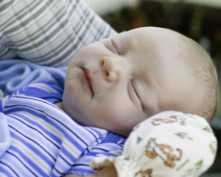 a baby has his eyes closed, while he is sleeping