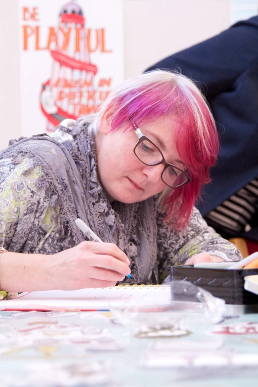 a woman is writing with a pencil and pen