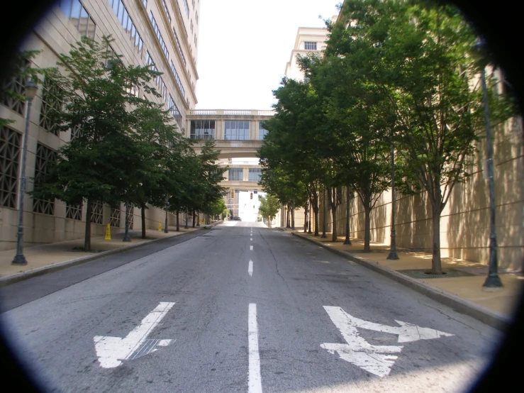 the view from an outside porthole of a street with trees and buildings