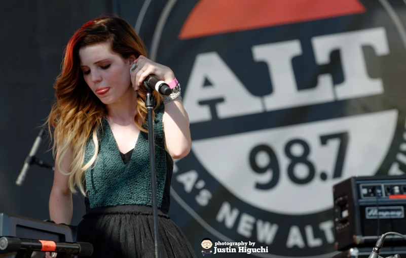 young lady holding an instrument while performing at an outdoor event