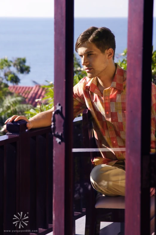 a young man is sitting on the porch