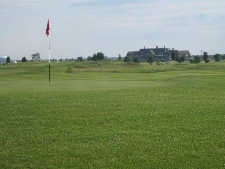 the house is nestled on top of the grassy hill