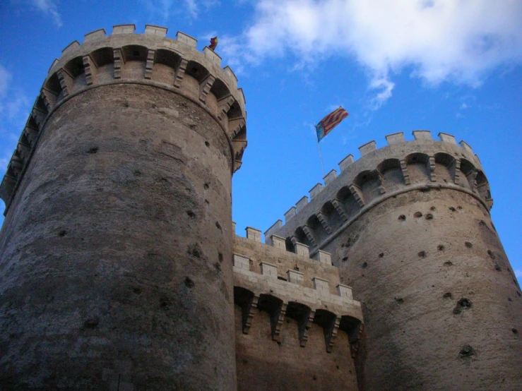 an old castle with a kite flying in the sky