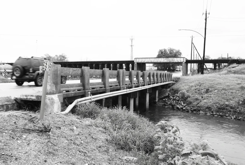 black and white pograph of a truck driving over a bridge