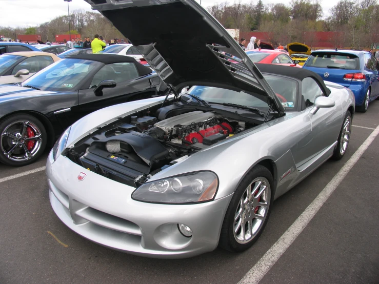 a silver car parked in front of a few others