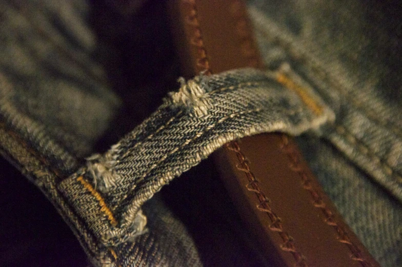 close up of jeans with holes and a piece of leather on the back