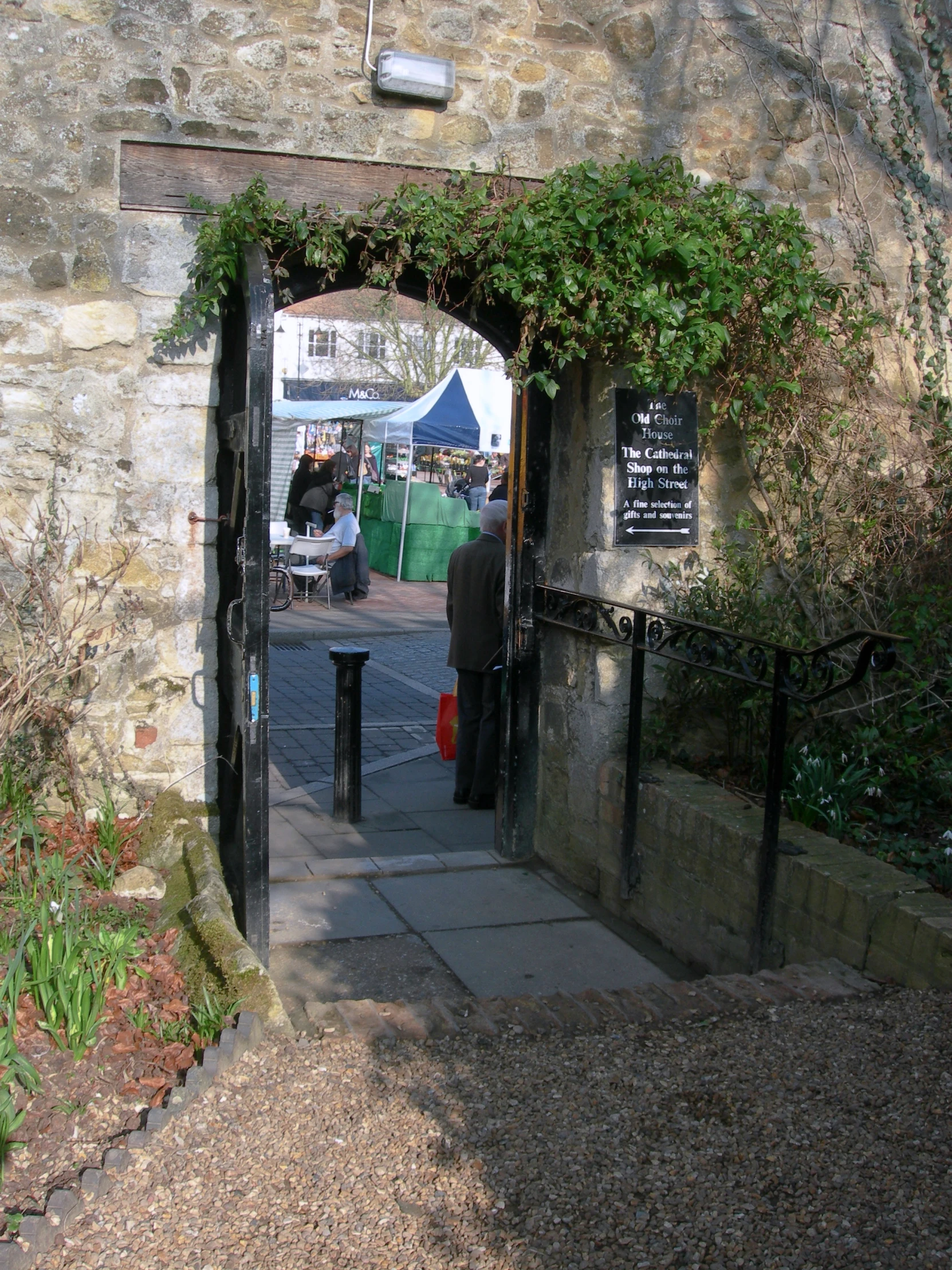 a couple of people stand outside of a stone building