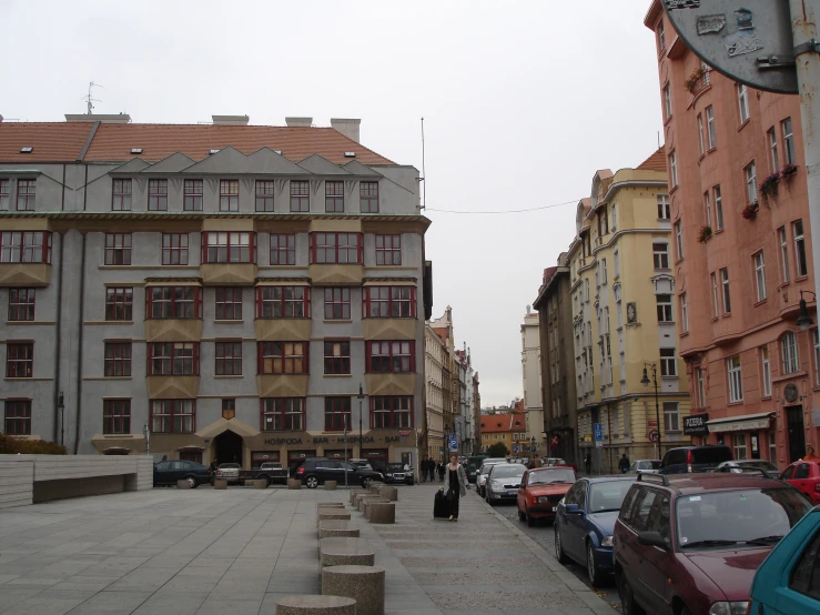 the cobblestones of a city street with cars parked along one side of them