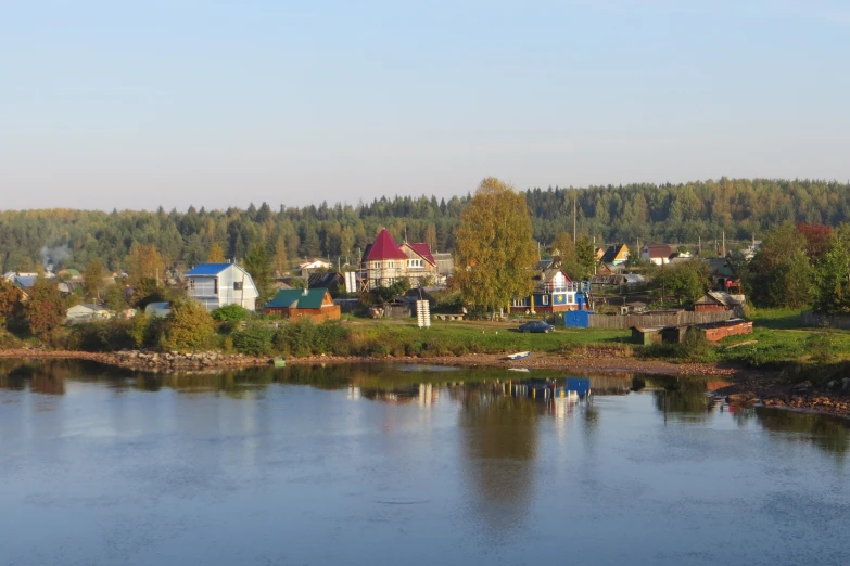 an aerial view of an open area, some houses and trees, a river and several buildings