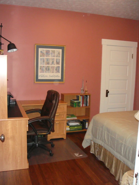 a bedroom with a bed, desk and chair and pictures on the wall