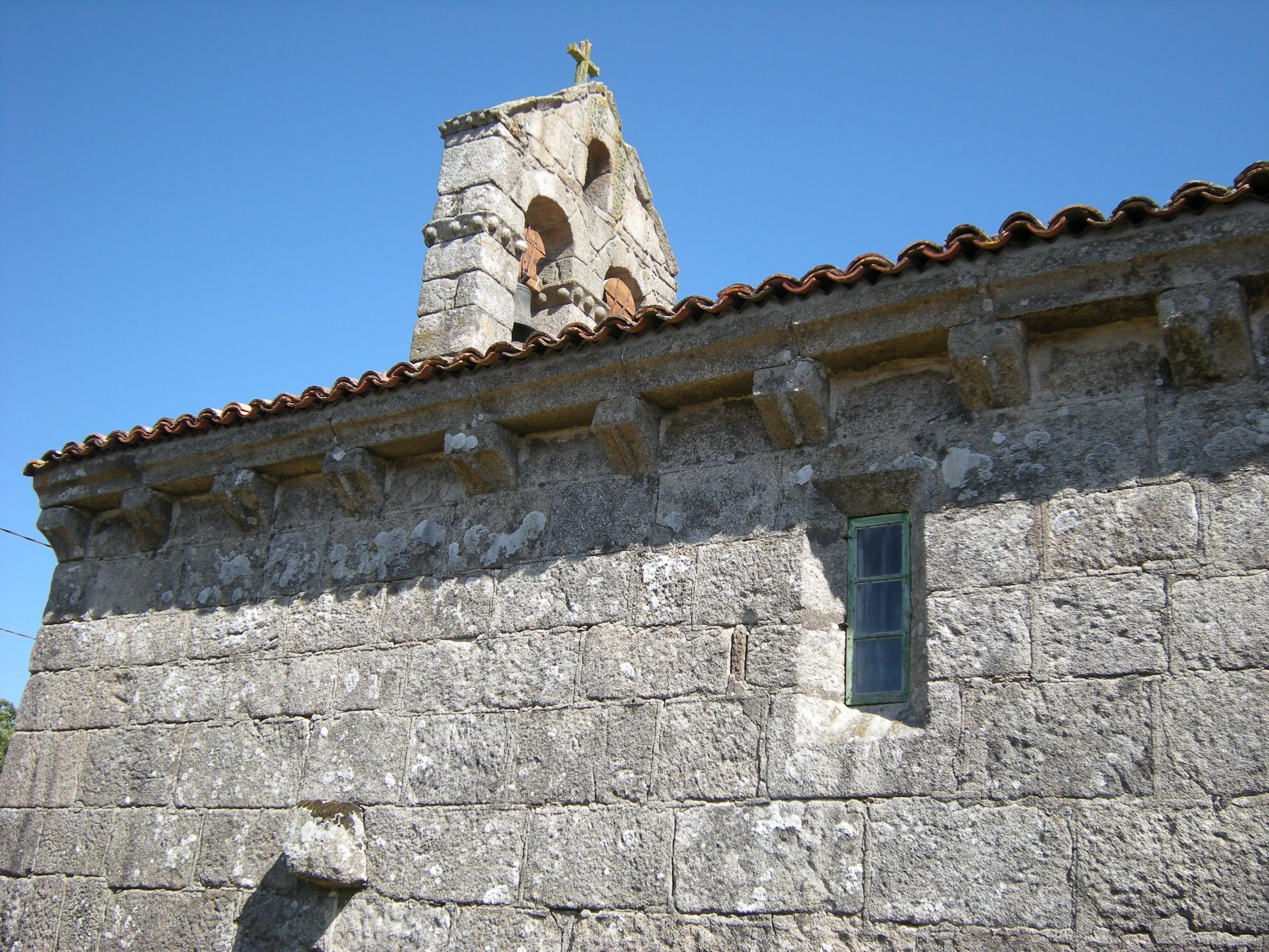 an old stone building has a large tower and cross on it