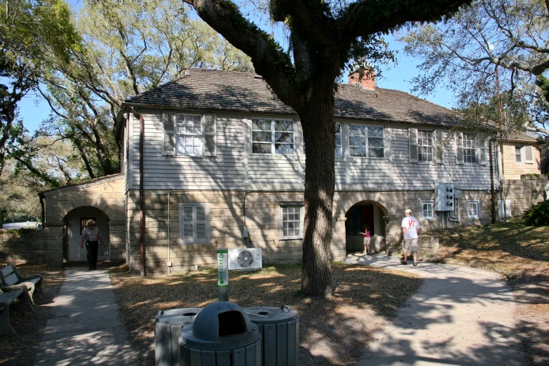 two people are standing in front of a stone house