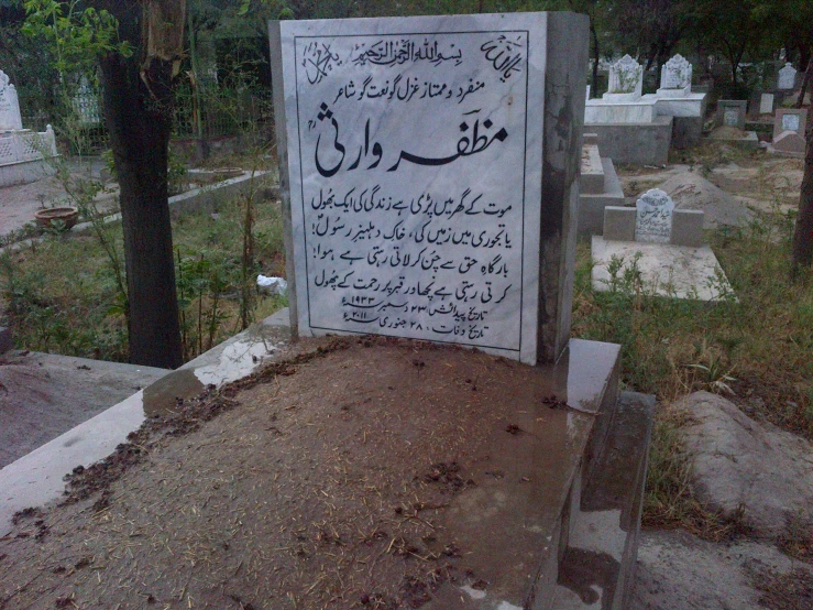 a grave with a sign in arabic on the side of it