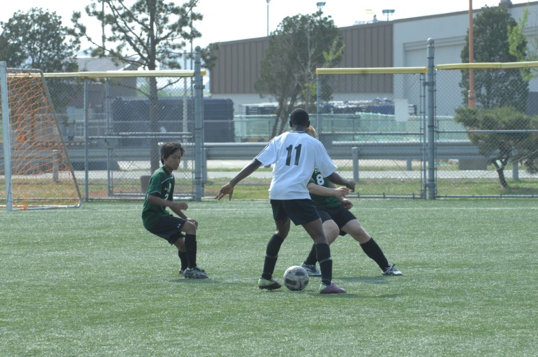 three soccer players in the middle of a game playing ball