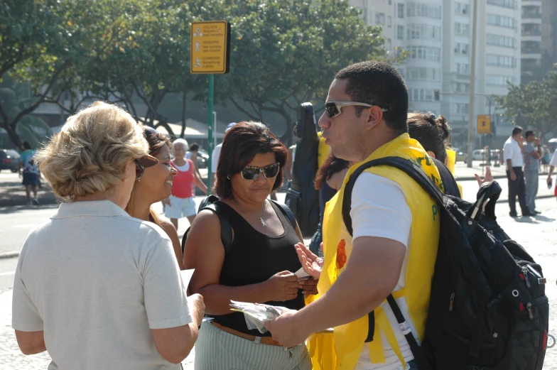 two women are shaking hands with a man on the sidewalk