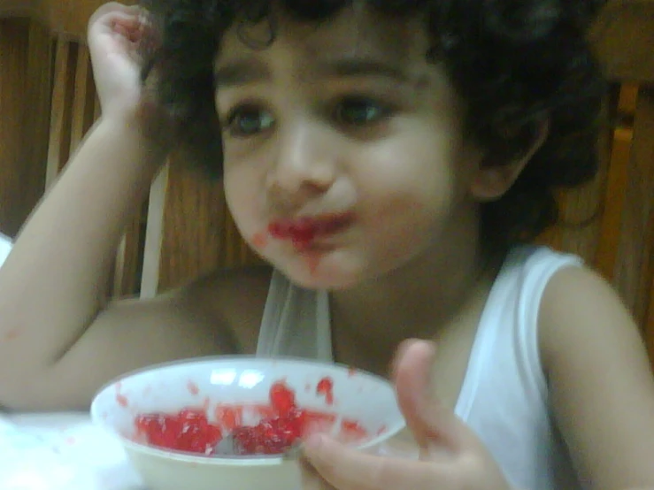 a child in a white shirt eating food