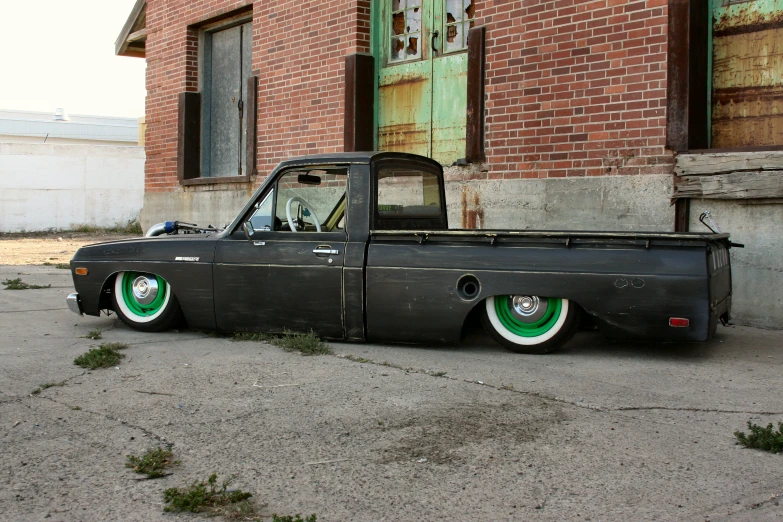 a black truck with wheels that have green rims