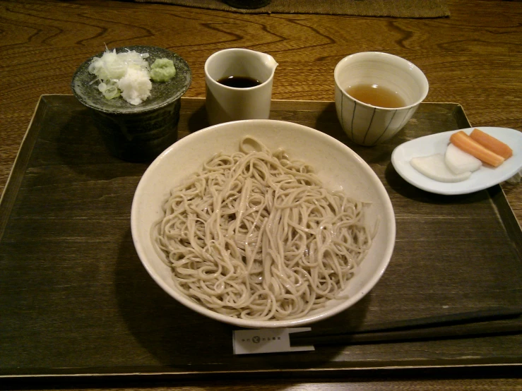 there is a bowl of noodle and chopsticks in front