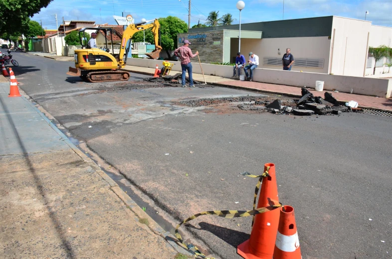 several construction workers are on the street near the construction site