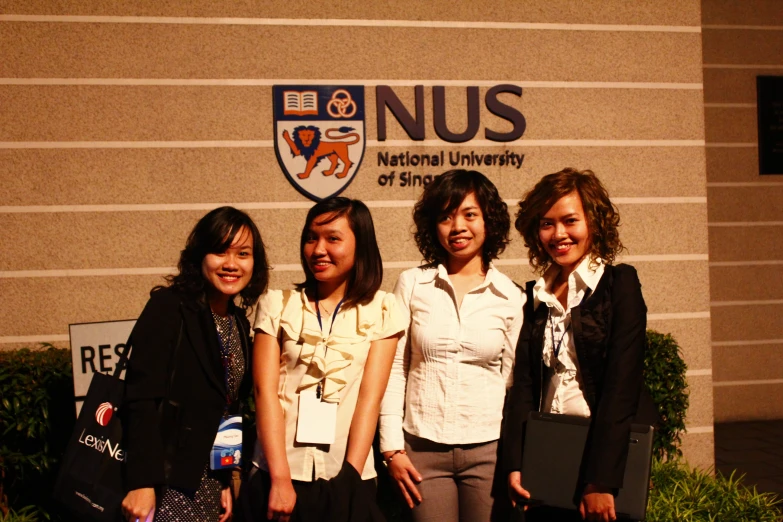 a group of s standing in front of a sign