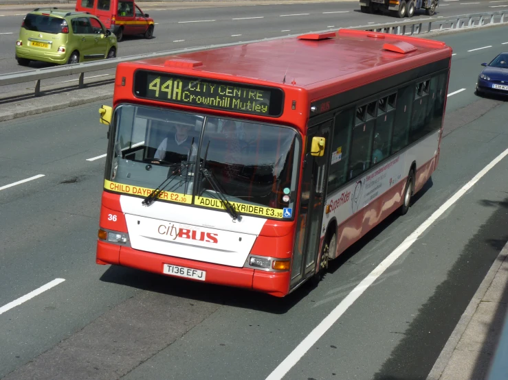 a red bus drives on a busy street