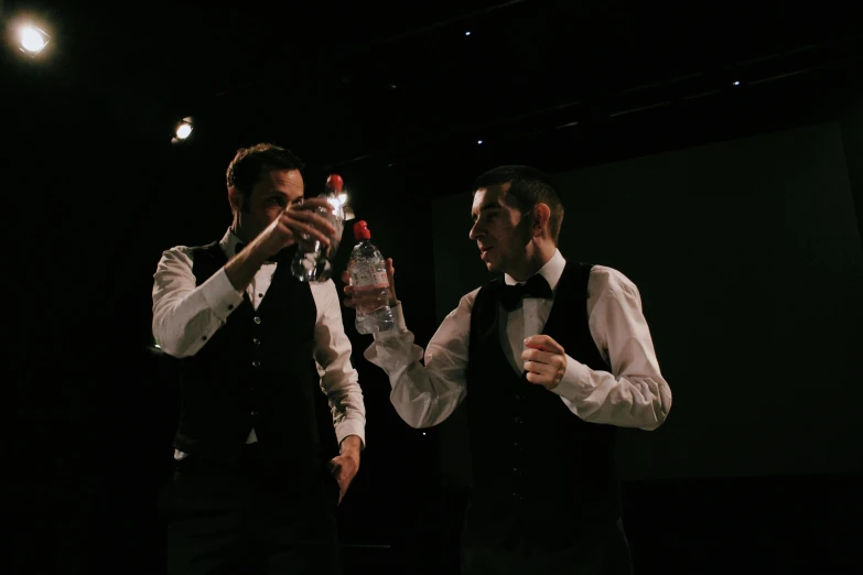 two men drinking while smoking on a stage