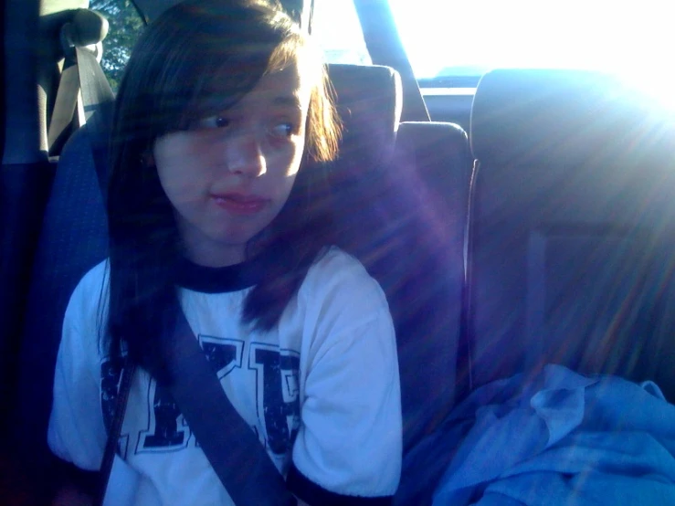 an asian woman sitting in a car on the passenger seat