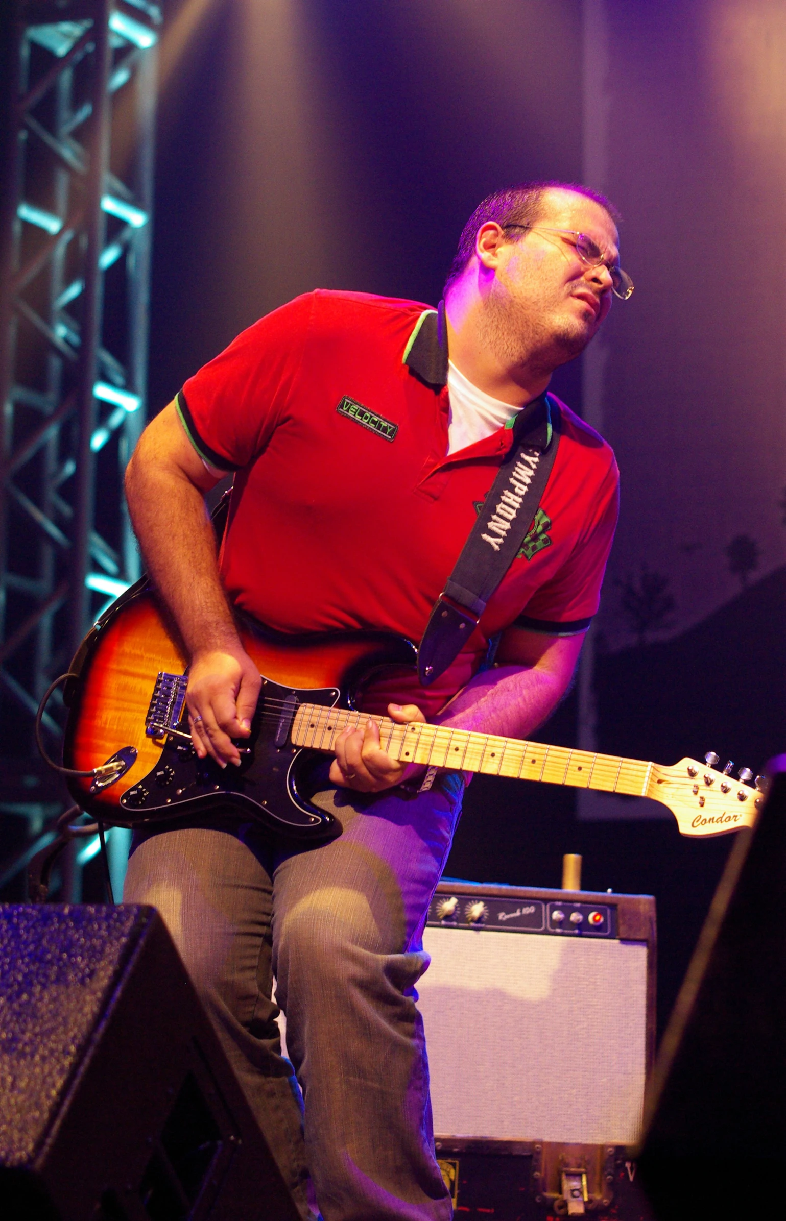 a man playing a guitar while standing on stage